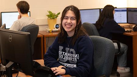Information Technology Student Worker smiling at desk